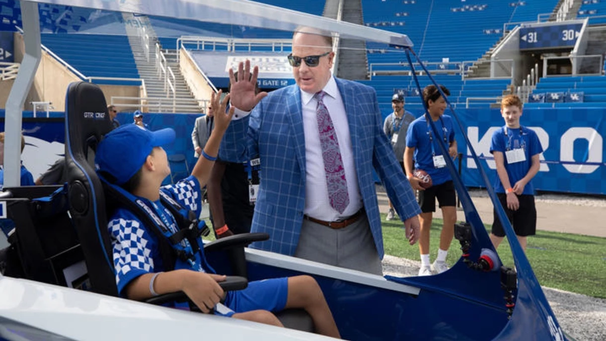 The pushcart, which made its debut on Saturday, Aug. 31, with Maximo Shemwell in the driver's seat, will become a staple among UK game day traditions. Shemwell is seen here high-fiving Coach Mark Stoops. Mark Cornelison | UK Photo.